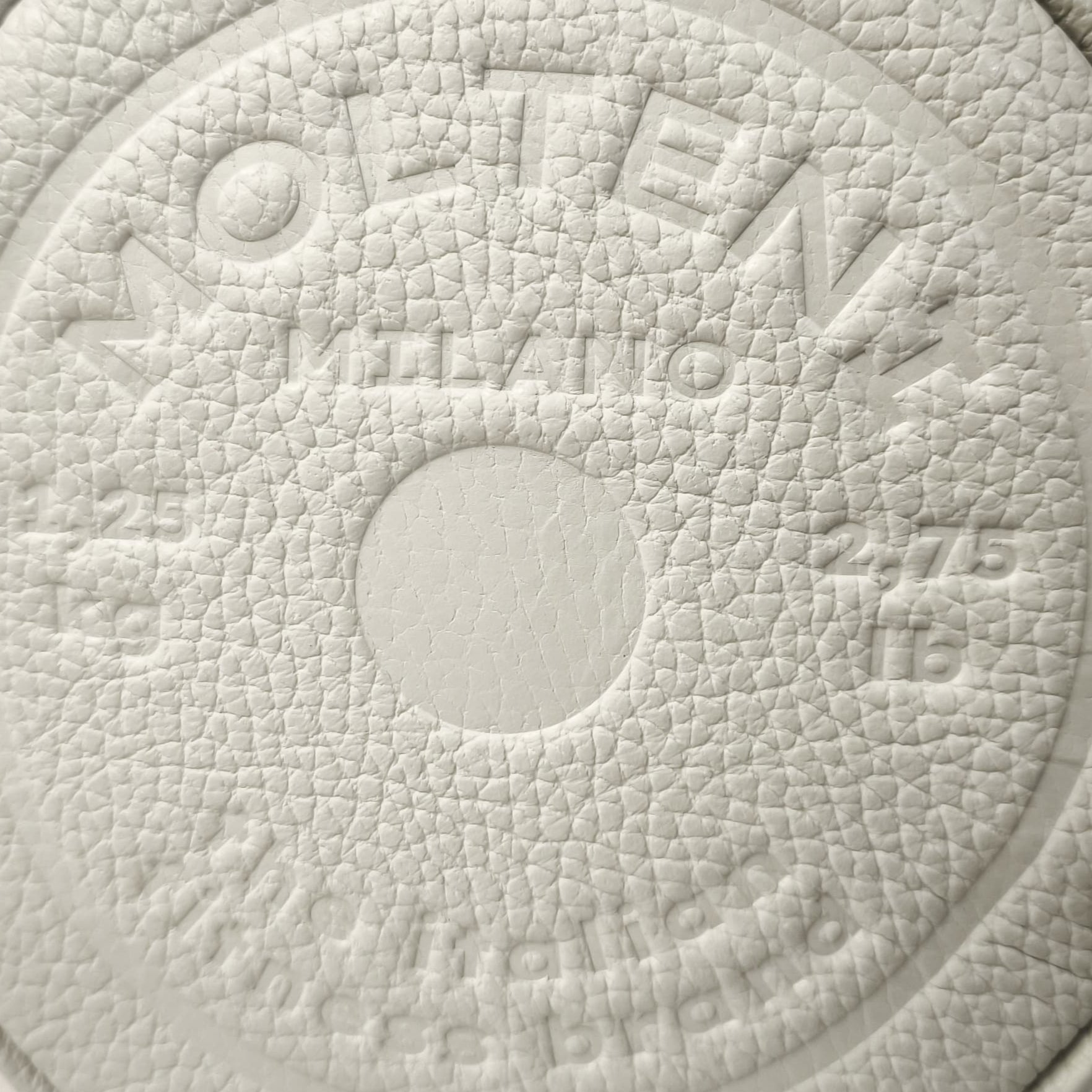 Personalizzazione a caldo in rilievo su pelle del design di un disco peso da bilanciere da 1,25kg presente su NORA small e ELEO small