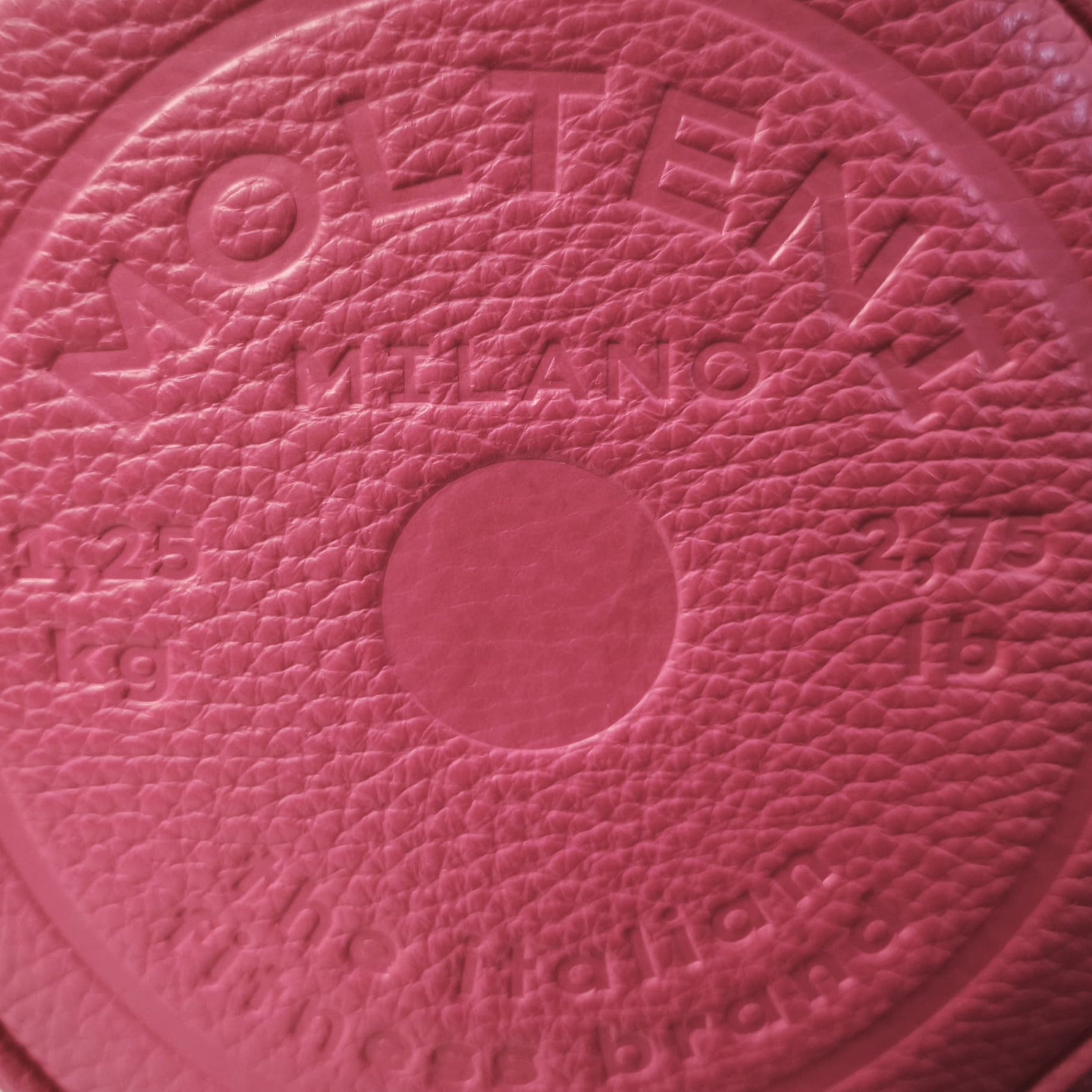 Personalizzazione a caldo in rilievo su pelle del design di un disco peso da bilanciere da 1,25kg presente su NORA small e ELEO small