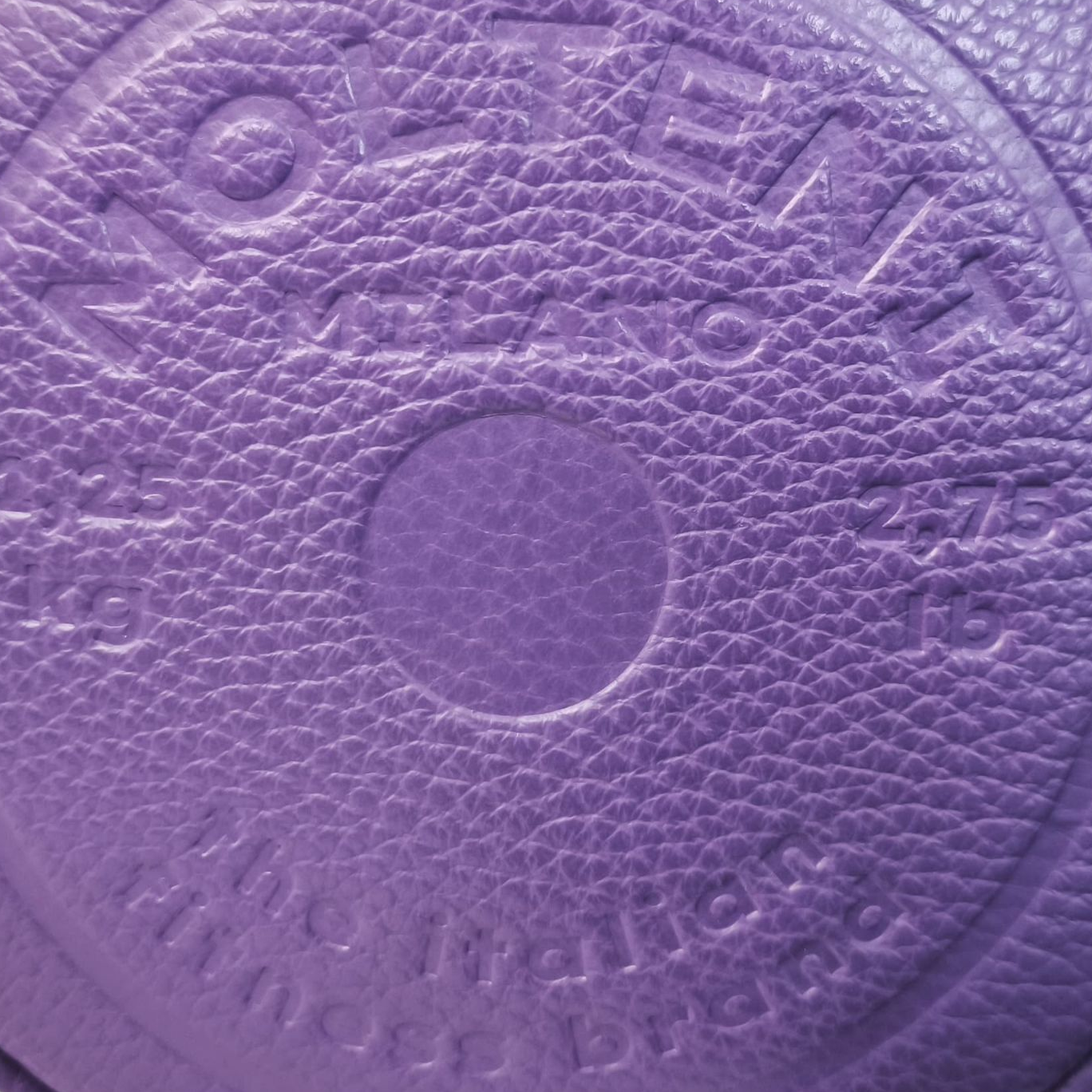 Personalizzazione a caldo in rilievo su pelle del design di un disco peso da bilanciere da 1,25kg presente su NORA small e ELEO small